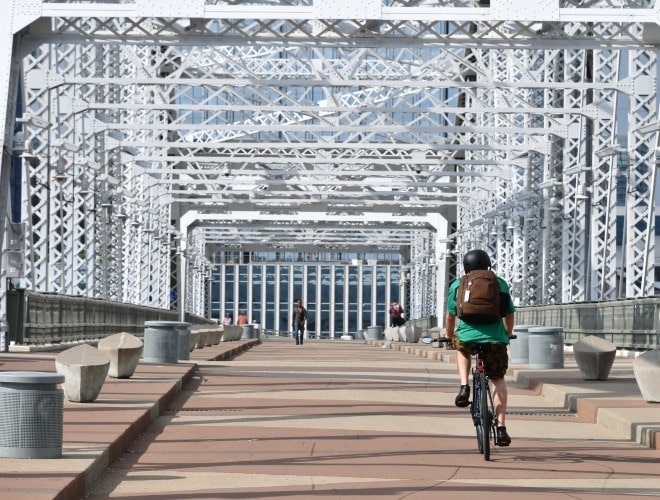 Man riding bike across bridge in Nashville