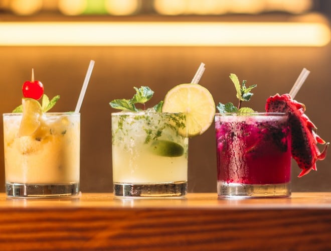 Three tropical drinks on a bar